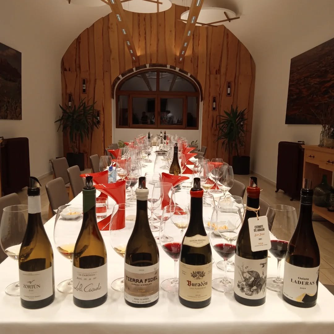 Cata en mesa larga con copas y botellas en Amaren